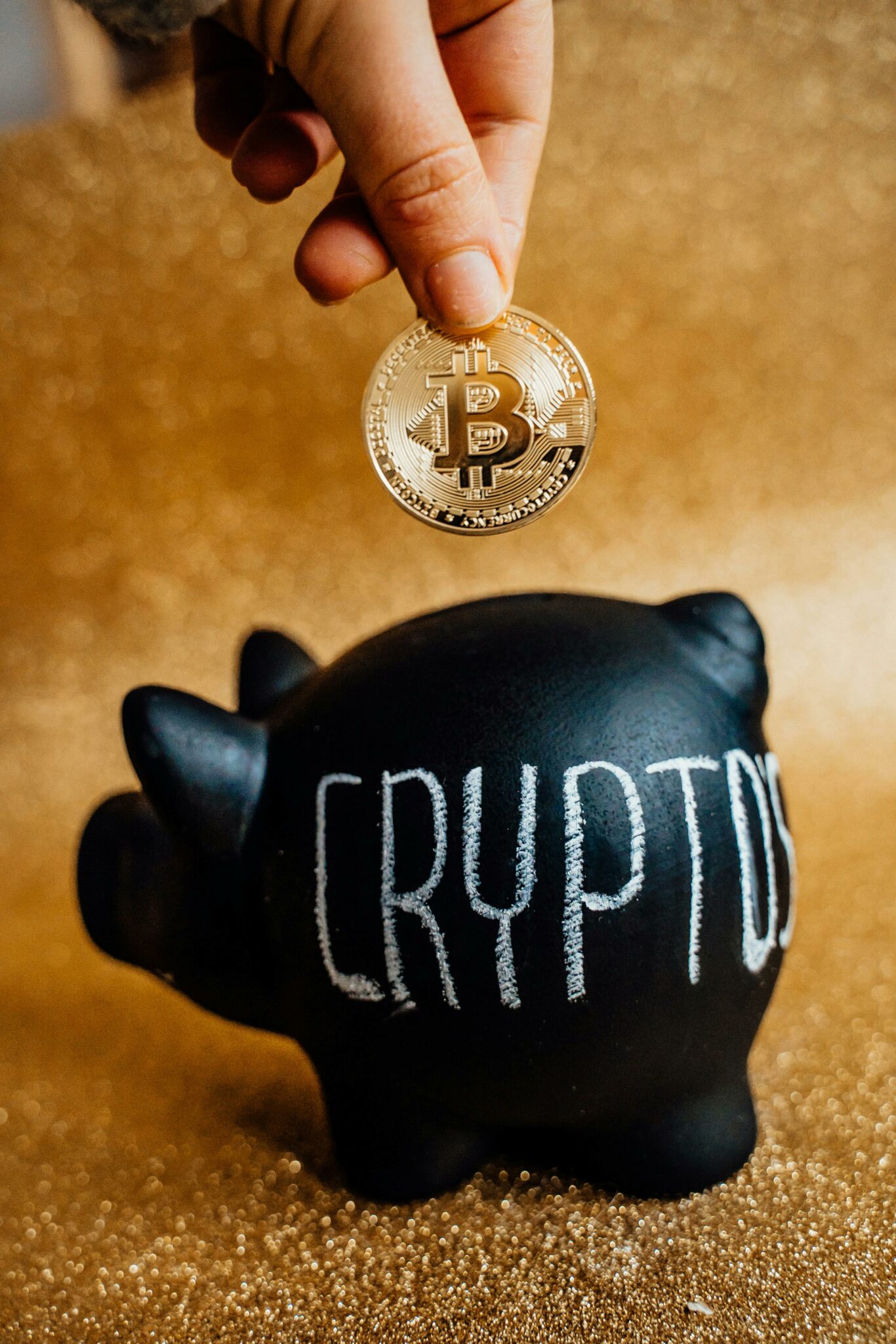 Man placing bitcoin into a piggy bank that has CRYPTO written on the side